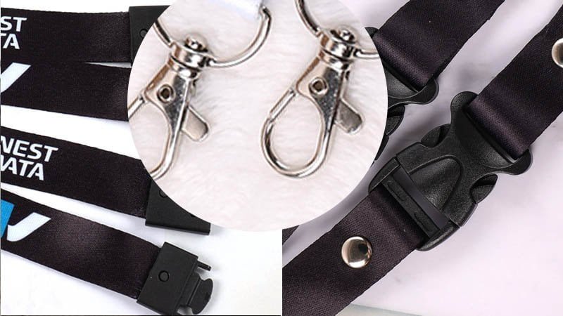 Lanyard safety components laid out on a table, including a breakaway clasp, a detachable buckle, and a secure badge attachment.
