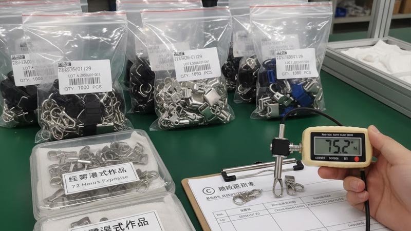 Bulk lanyard attachment QC setup with labeled batches, sampling inspection, and verification testing
