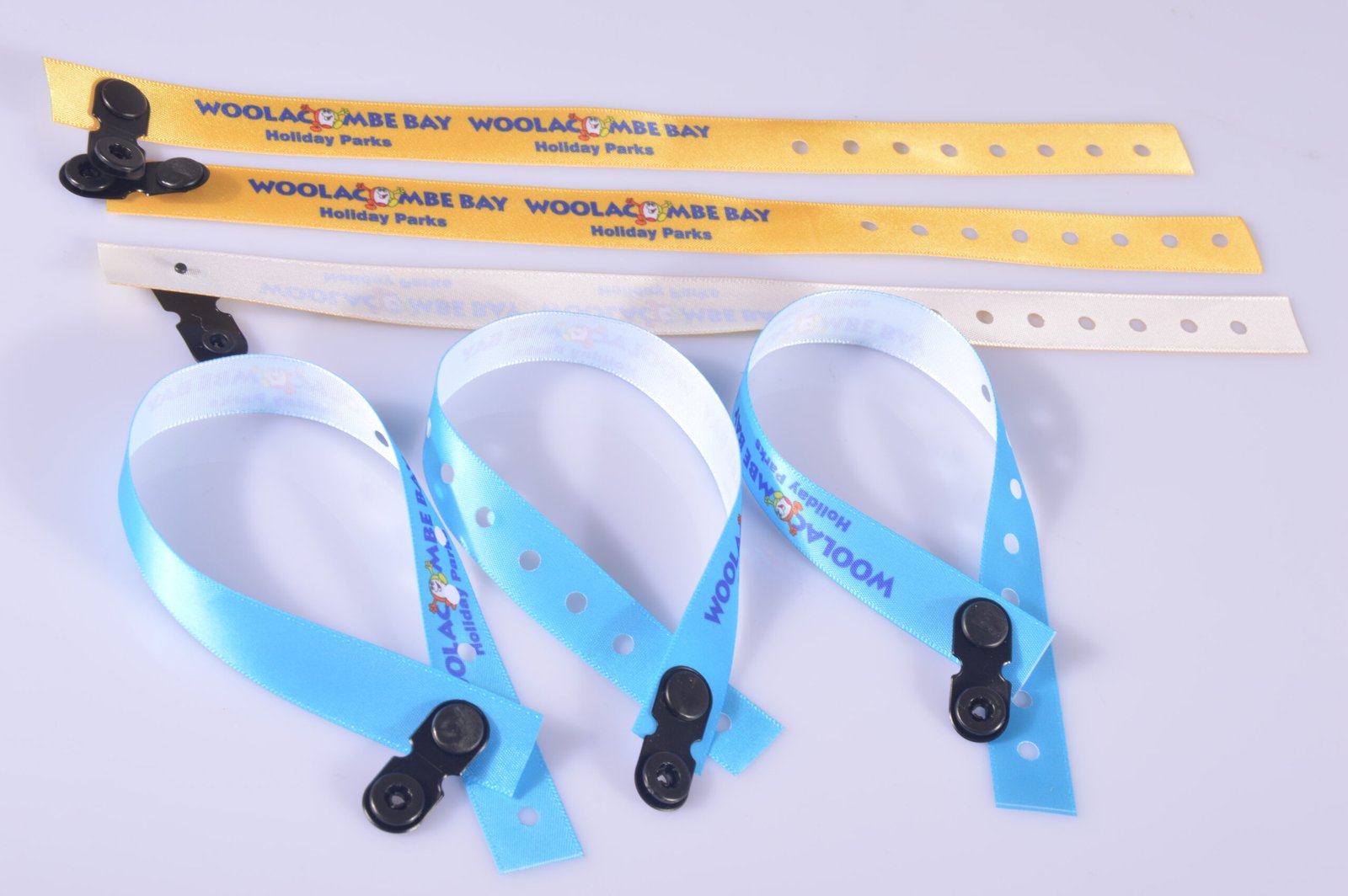 Bulk set of custom event wristbands with punch holes and secure fasteners