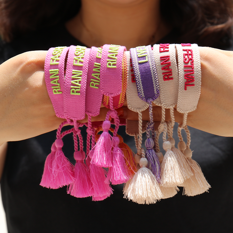 premium embroidered wristbands with custom text and tassel design