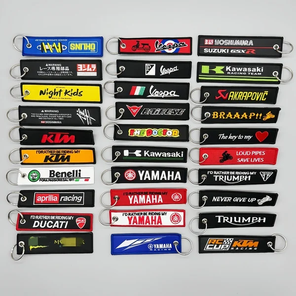 Large assortment of colorful embroidered motorcycle and racing key tag keychains with metal split rings