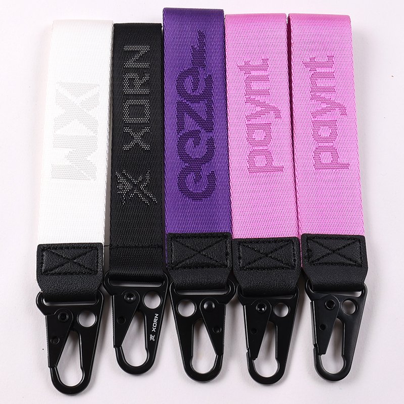 Custom woven wristlet keychains in pastel colors with branded lettering and black snap hooks