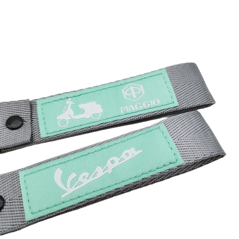 Two gray and mint green scooter key tag lanyards with sewn logo patches on a white background