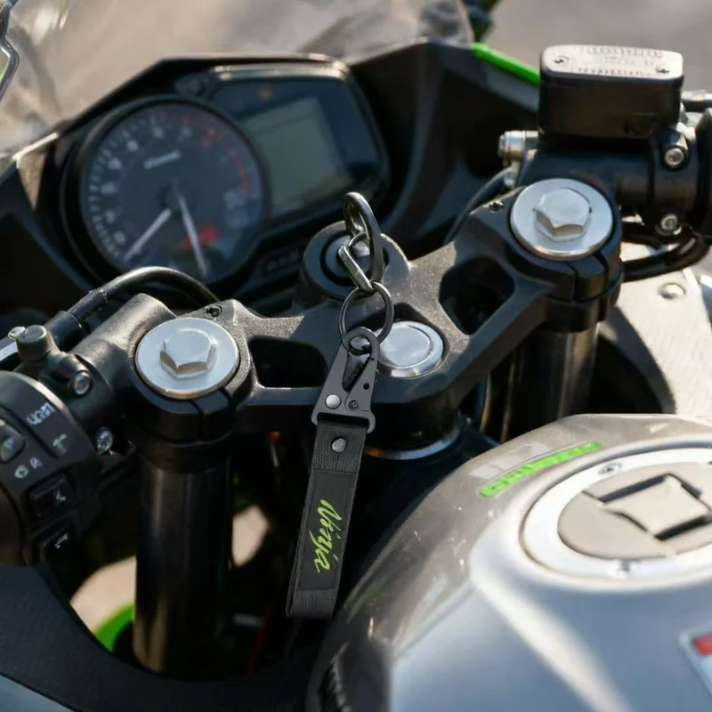 Short black motorcycle key tag lanyard attached to a key in a motorcycle ignition