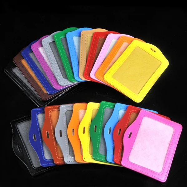 Fan arrangement of multicolor vertical ID badge holders with front windows against a black background.