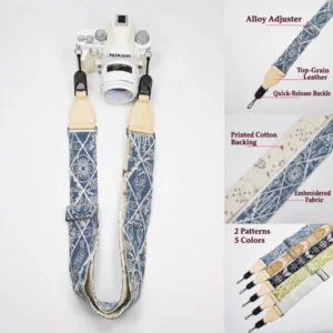 Blue patterned camera strap on a white Nikon camera with cream leather ends, quick-release connectors and fabric detail panels