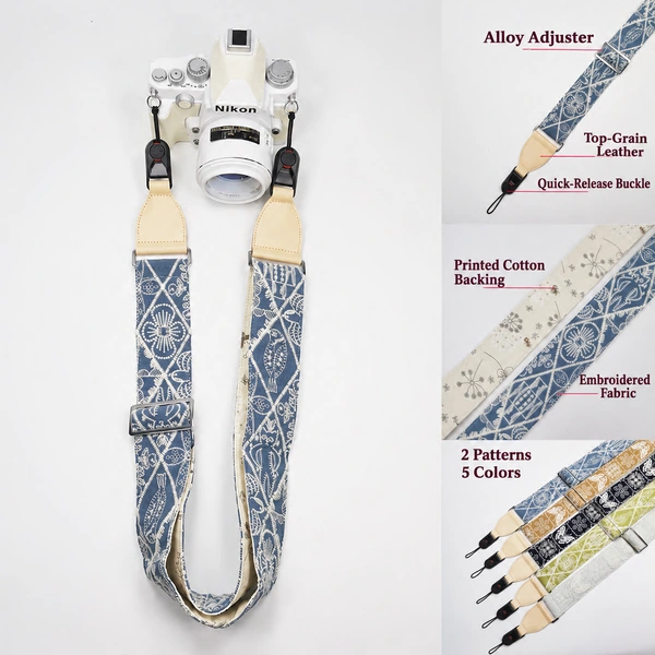 Blue patterned camera strap on a white Nikon camera with cream leather ends, quick-release connectors and fabric detail panels