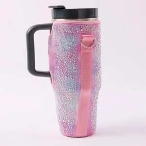 Glitter effect pink sleeve around a handled tumbler with its black handle exposed and a side attachment loop