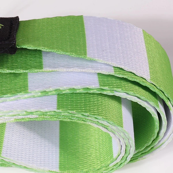 Close-up of folded green and white striped webbing with a black reinforced end