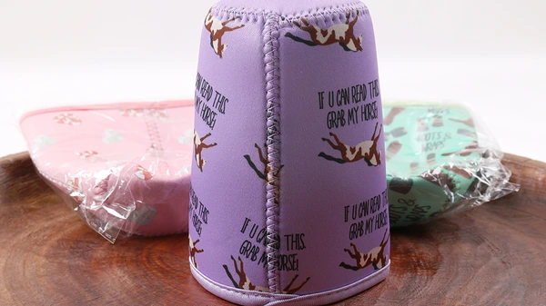 Lavender printed cup sleeve with a visible vertical stitched seam beside pink and mint packaged sleeves