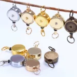 Round metal badge reels in silver, gold and antique finishes with key ring attachments