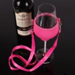 Pink holder supporting a stemmed wine glass beside a wine bottle, with a pink neck lanyard