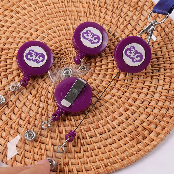 Purple round logo badge reels with clear snap straps and a metal back clip