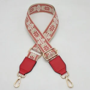 Red and beige floral-patterned shoulder strap with red end tabs and gold-colored clips
