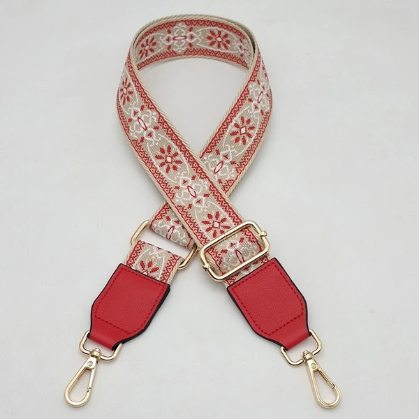 Red and beige floral-patterned shoulder strap with red end tabs and gold-colored clips