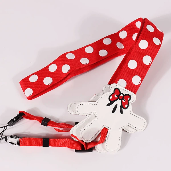 Red camera strap with white polka dots, white decorative character-shaped ends and red attachment webbing