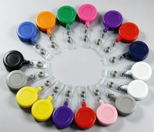 Round plastic badge reels in assorted colors arranged in a circle with clear snap straps