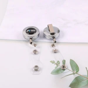 Two silver round badge reels showing logo face, back belt clip and clear snap straps