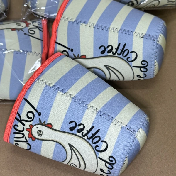 Blue and cream striped cup sleeves with chicken illustrations, red edging and visible stitched seams
