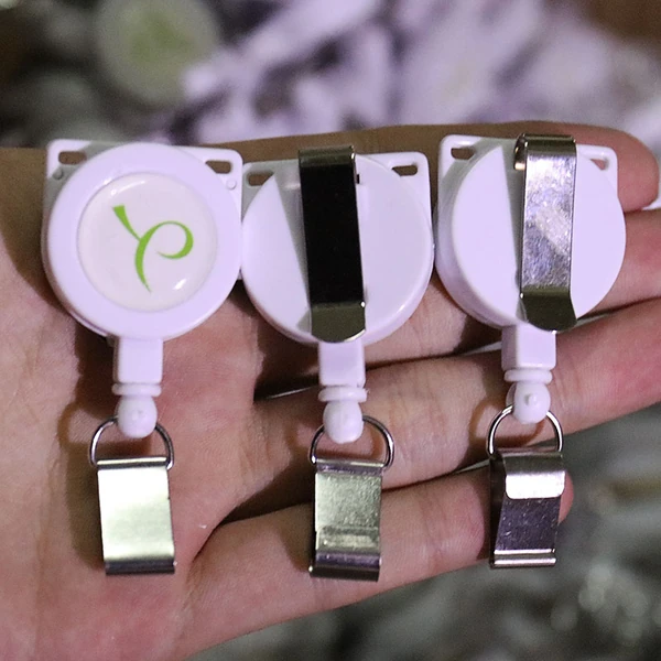 Three white round badge reels showing logo face and different metal back clips